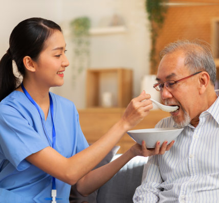 caregiver feeding senior man